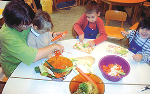 Kinder rüsten Gemüse an einem Tisch
