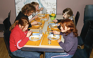 Kinder an einem Mittagstisch beim Essen