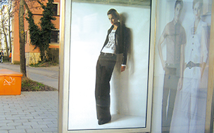 Bild einer sehr schlanken Frau an einer Bushaltestelle