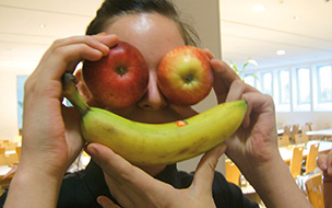Ein Gesicht mit zwei Äpfeln als Augen und einer Banane als Mund