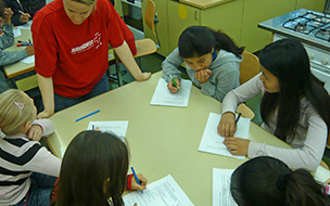 Jugendliche am Tisch mit Schreibzeug
