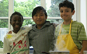Drei Jungen unterschiedlicher Herkunft beim Kochen