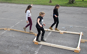 drei Mädchen balancieren auf Holzlatten