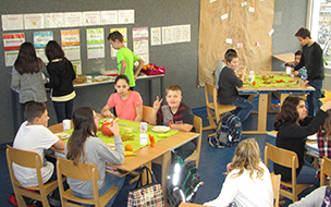 Schulkinder sitzen im Klassenraum beim Essen am Tisch