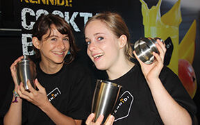 Zwei junge Frauen mit Cocktailshaker